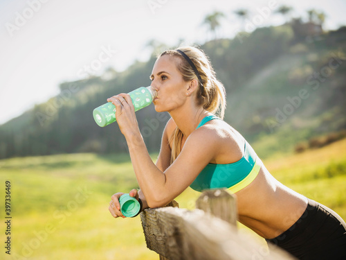 Woman drinking from bottle photo