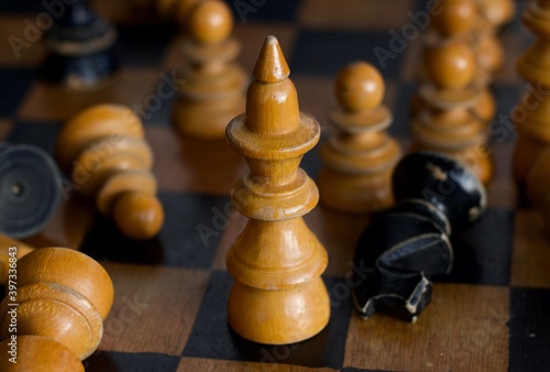 Vintage Wooden Handcrafted Queen Chess Figure Piece. Among other pawns, on the Chess Board