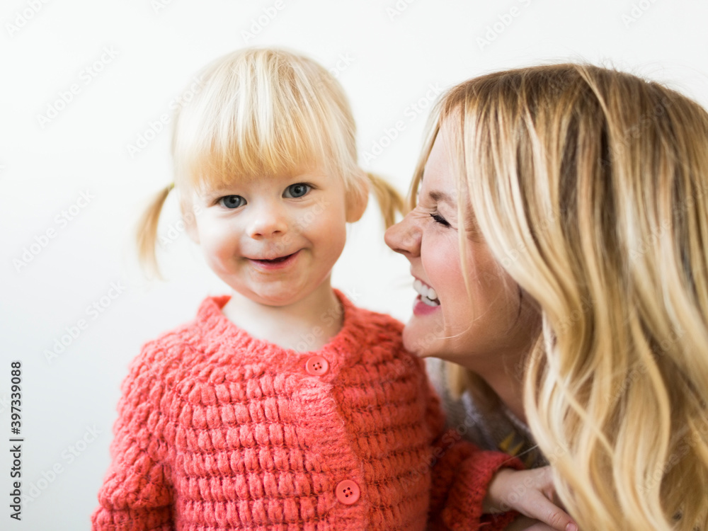 Cute girl (2-3) smiling at camera with mother Cute girl (2-3) smiling at camera with mother