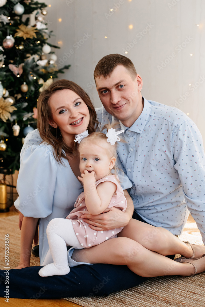 close-up portrait of a beautiful family. Mom dad and daughter on the background of the Christmas tree close-up portrait of a beautiful family. Mom dad and daughter on the background of the Christmas tree