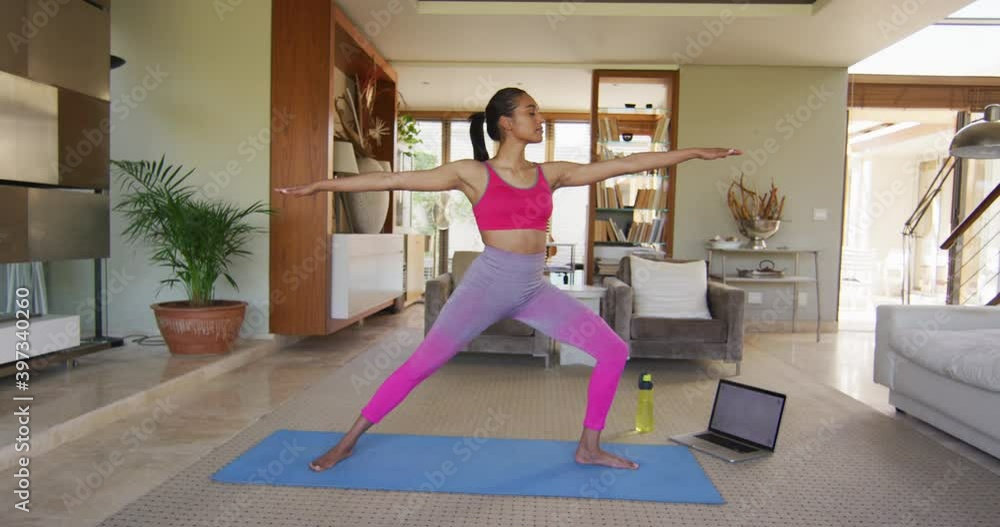 Mixed race woman practising yoga at home Mixed race woman practising yoga at home