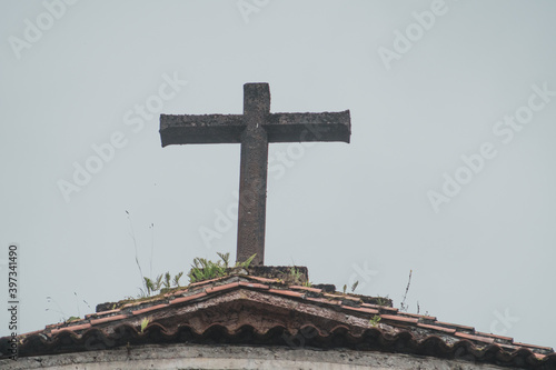 stone cross on top of a building with a clear sky in the background photo