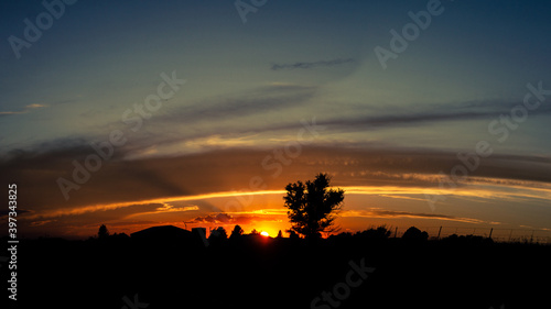 Panorama shot of red sunset behind houses on horizon in america