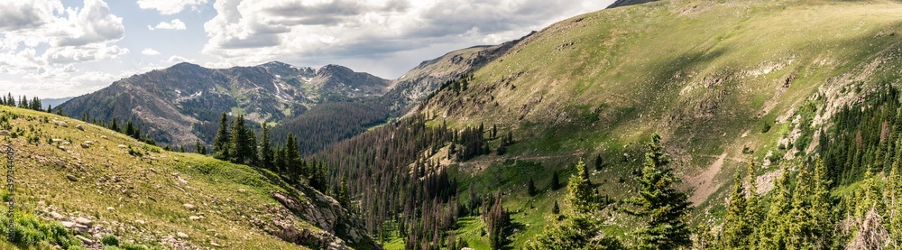 Panorama shot of green valley with remnants of snow in Rocky mountains antional park in america Panorama shot of green valley with remnants of snow in Rocky mountains antional park in america