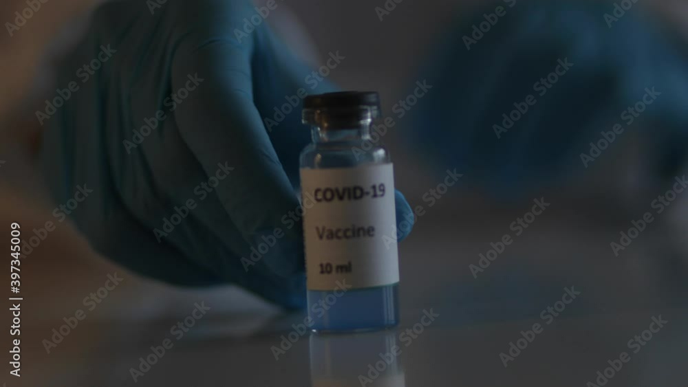 Concept of Covid 19 vaccine vaccinating, development and creation, doctor or scientist in laboratory holding a single dose of 2019-ncov vaccine, a syringe and ampule with SARS-CoV-2 vaccination Concept of Covid 19 vaccine vaccinating, development and creation, doctor or scientist in laboratory holding a single dose of 2019-ncov vaccine, a syringe and ampule with SARS-CoV-2 vaccination