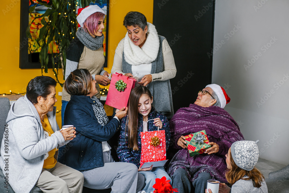 Fototapeta premium three generations of Latin women celebrating Christmas at home in Mexico