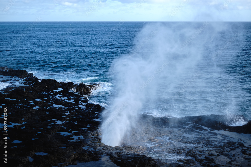 a large wave crashing into rocks