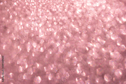 Defocused abstract pink twinkle light background. Pink gold glittery bright shimmering background use as a design backdrop.