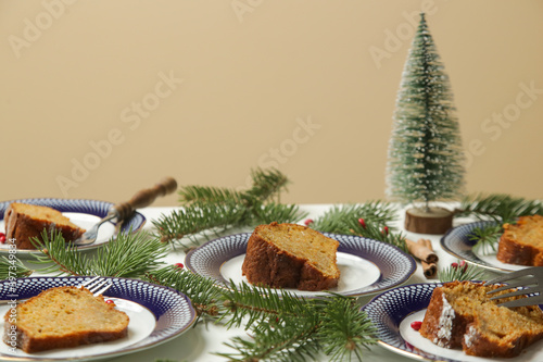 Fototapeta Naklejka Na Ścianę i Meble -   Festive Christmas table setup. Slices of bundt cake on plates. 
