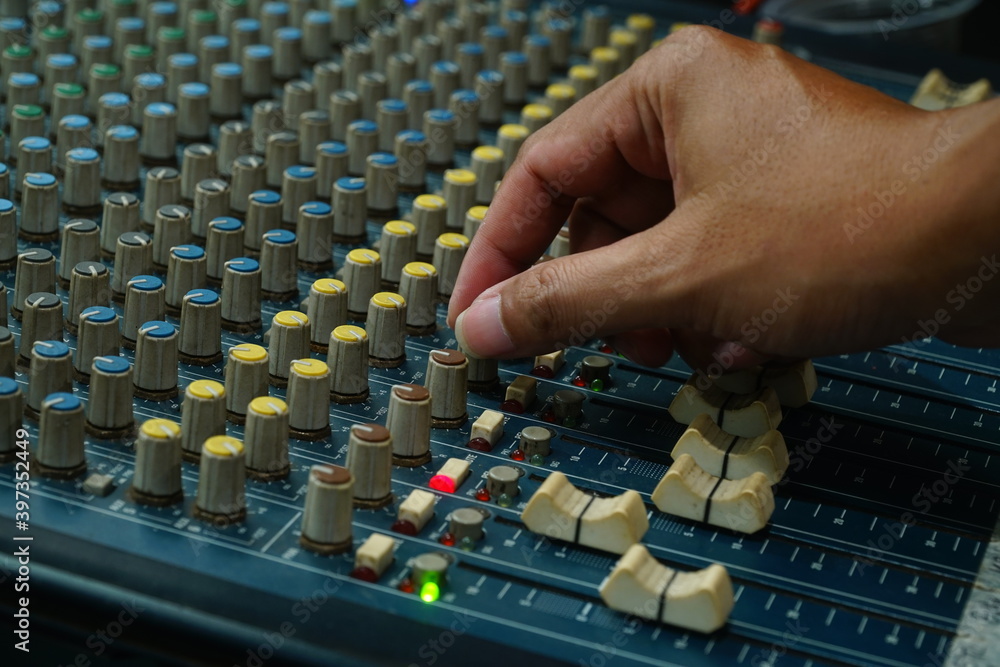 Audio sound mixer with focus to the man's hand turning the knob Audio sound mixer with focus to the man's hand turning the knob