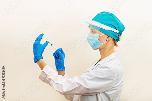 Doctor or nurse holding hands flu vaccine on beige background  measles injection syringe for baby  man  woman vaccination  medicine and drug concept. Vaccination against Coronavirus covid-19 pandemic 