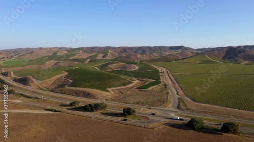Wide shot of vineyard with Highway 101 running through in Central California