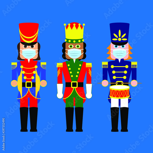 Three cute traditional holiday nutcracker toy dolls wearing surgical face masks during coronavirus pandemic