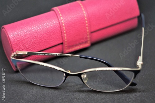 Glasses with a pink case on a dark background.