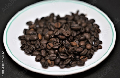 Coffee beans on a white saucer.