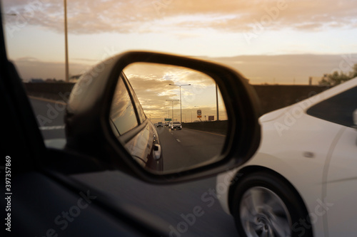 Fototapeta Naklejka Na Ścianę i Meble -  car view mirror on sunset. sunset car driving scene.