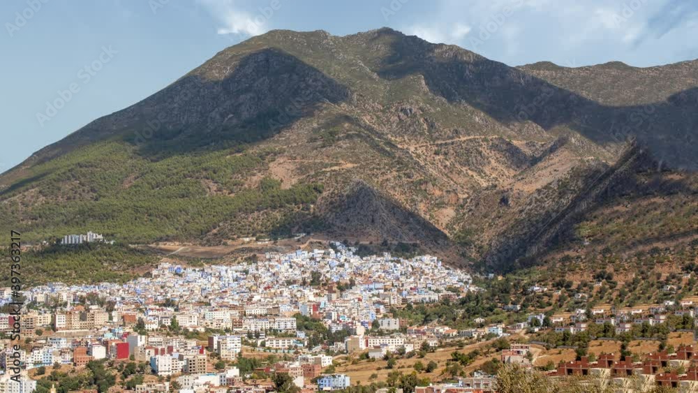 Time lapse panoramic view of chefchaouen during a sunny cloudy day. There is blue african village with the mountain in background Time lapse panoramic view of chefchaouen during a sunny cloudy day. There is blue african village with the mountain in background