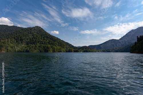 Green mountain lake among the rocks on which grow tall spruces