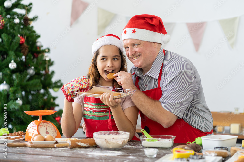 Family cooking is fun. Happy father and cute child daughter having fun preparing baking cookies biscuit cooking together in kitchen with Christmas tree at home. Father and daughter spending together Family cooking is fun. Happy father and cute child daughter having fun preparing baking cookies biscuit cooking together in kitchen with Christmas tree at home. Father and daughter spending together