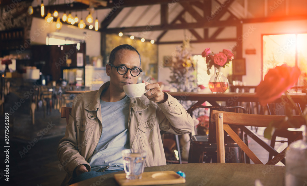asian man drinking hot coffee in cafe