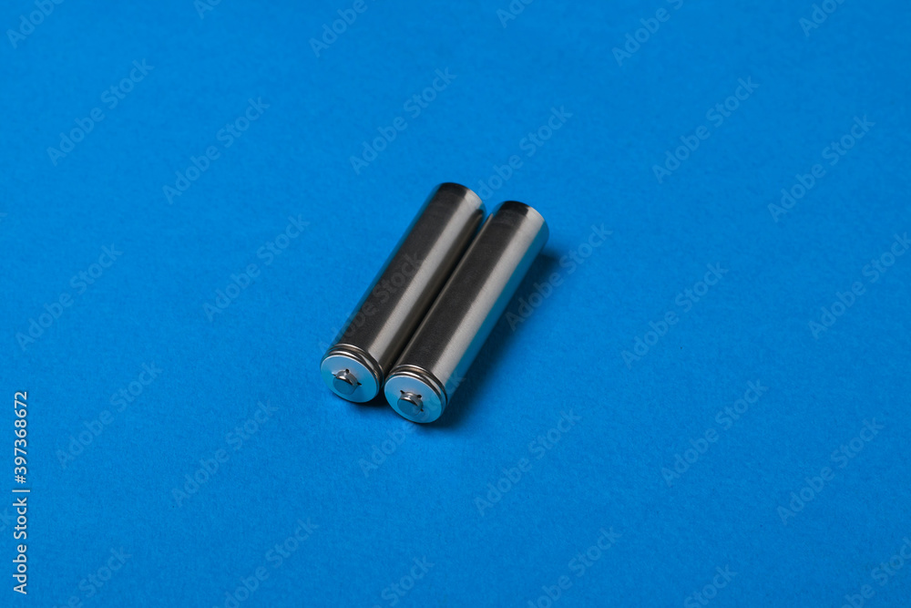 Naklejka premium Two AA batteries on a blue background.