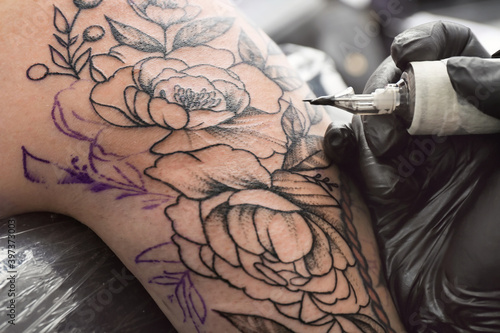 Professional artist making tattoo in salon photo