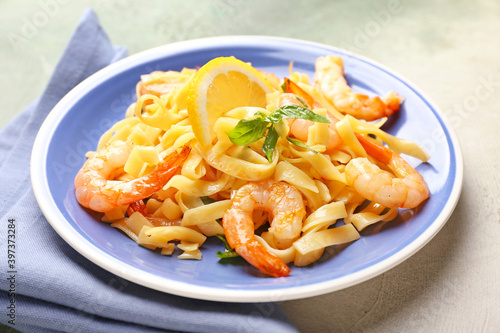 Plate of tasty pasta with shrimps on table