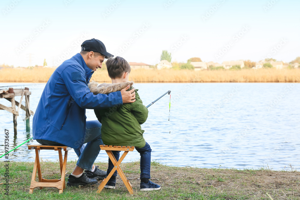 Little boy and his father fishing on river Little boy and his father fishing on river