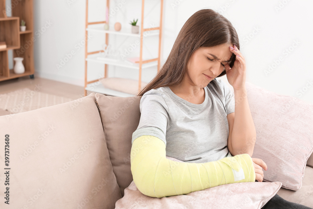 Young woman with broken arm at home