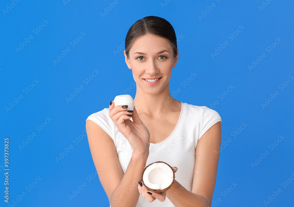 Beautiful young woman with coconut and cream on color background Beautiful young woman with coconut and cream on color background