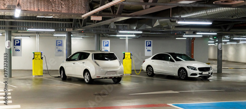 Electric cars are charged from the charging station in the parking lot of the shopping center.