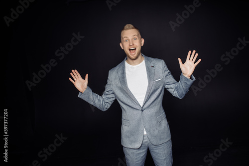 Photo portrait of amazed surprised man wearing stylish suit gesturing hands opened mouth isolated on black color studio background