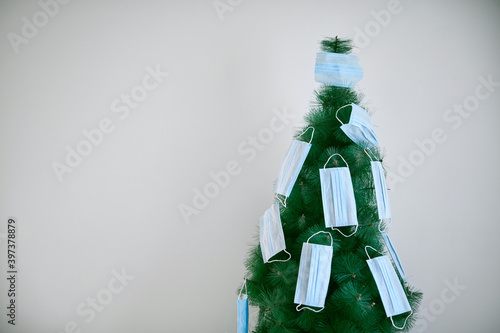 Christmas tree decorated with surgical masks - 2020/2021 coronavirus pandemic concept. photo