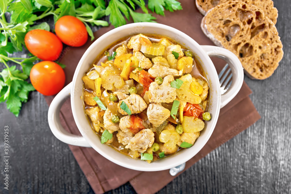 Chicken with vegetables and peas in saucepan on board top Chicken with vegetables and peas in saucepan on board top