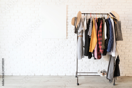 Billede på lærred Rack with colorful clothes on hangers and frame canvas for mock up over white br