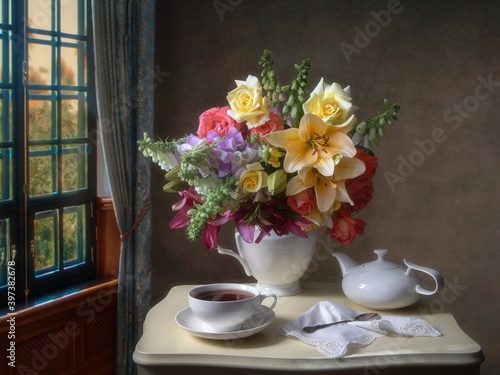 Still life with bouquet of flowers on a tea table photo