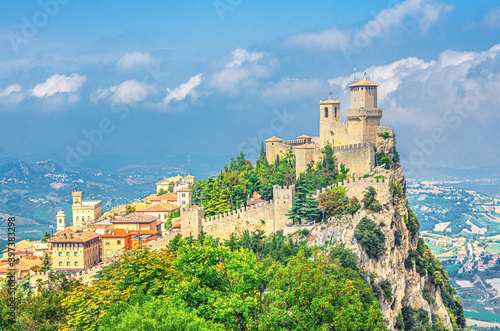 Republic San Marino Prima Torre Guaita first fortress tower with brick walls on Mount Titano stone rock with green trees, aerial top panoramic view of landscape valley and hills of suburban district