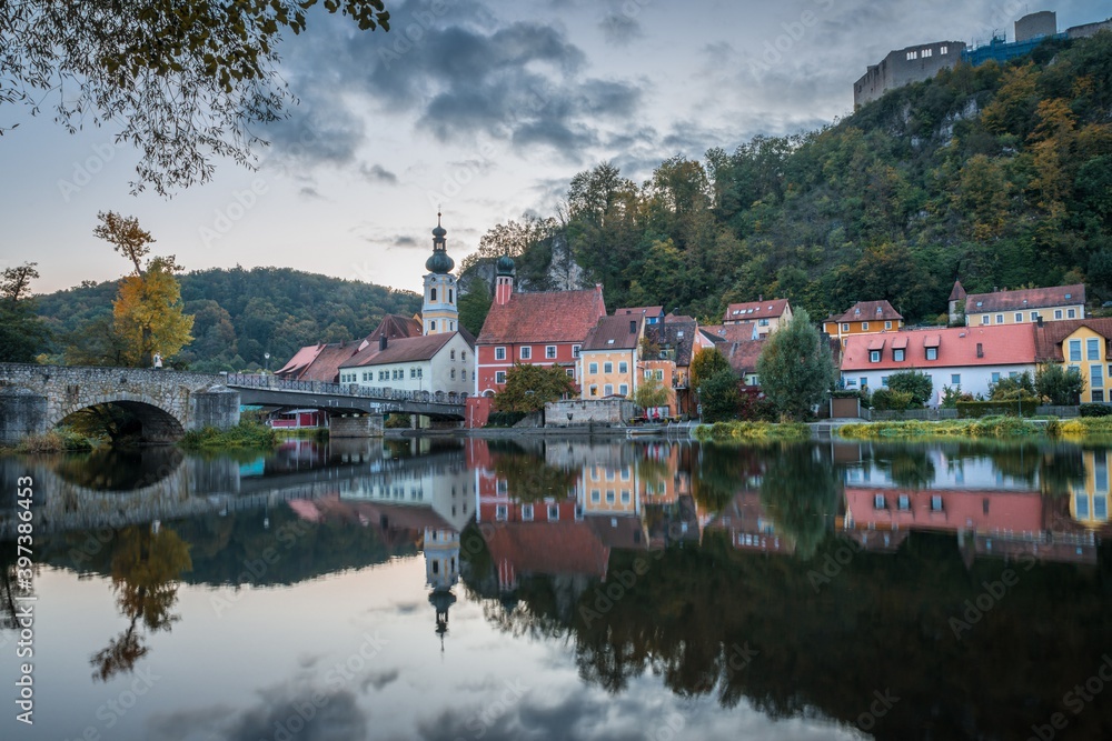 Bild einer Panorama Stadtansicht des Markt Kallmünz Kallmuenz in Bayern und dem Fluss Naab und Vils und der Burg Ruine auf dem Berg, Deutschland