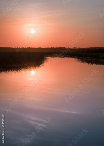 Scenic sunset landscape with water reflections and mood colors at autumn evening in Finland.