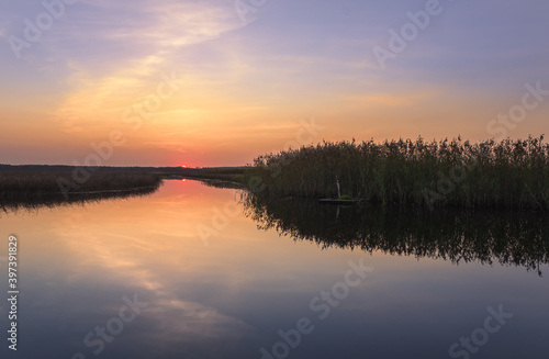 Scenic sunset landscape with water reflections and mood colors at autumn evening in Finland.