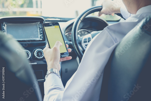 Hand using Cellphone while driving car,Businessman,parking