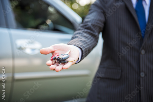close up of businessman or salesman giving car key,concept of transportation with automobile second hand sale