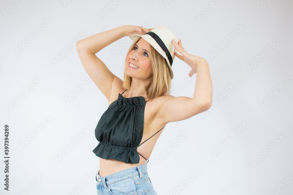 Young beautiful woman wearing straw hat over isolated white background looking away to side with smile on face, natural expression. Laughing confident. Young beautiful woman wearing straw hat over isolated white background looking away to side with smile on face, natural expression. Laughing confident.