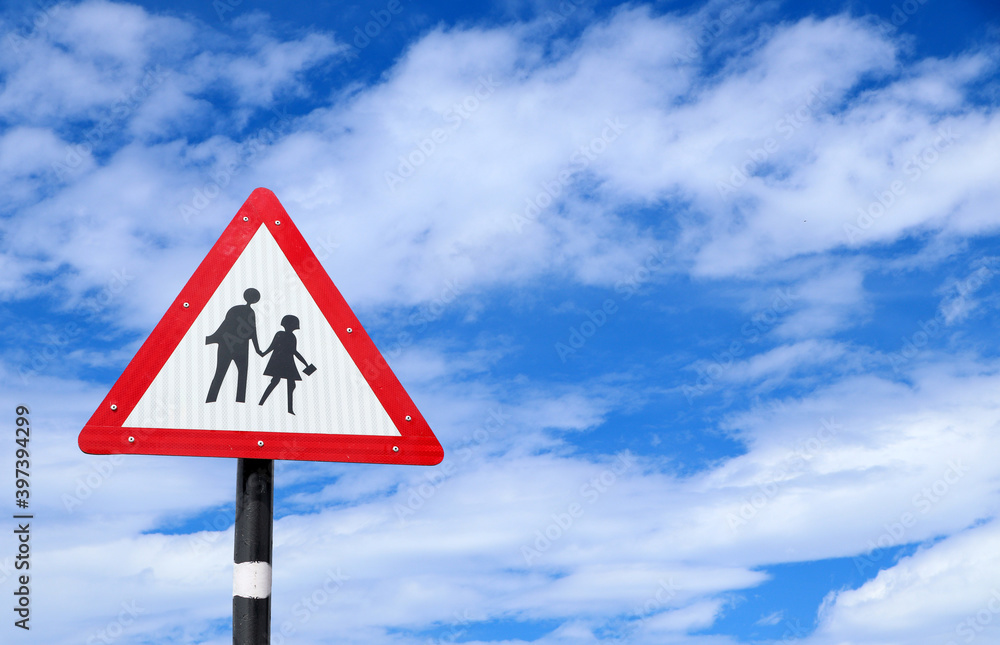School Warning Sign with the sky background, School zone or children crossing sign isolated on cloudy sky background School Warning Sign with the sky background, School zone or children crossing sign isolated on cloudy sky background