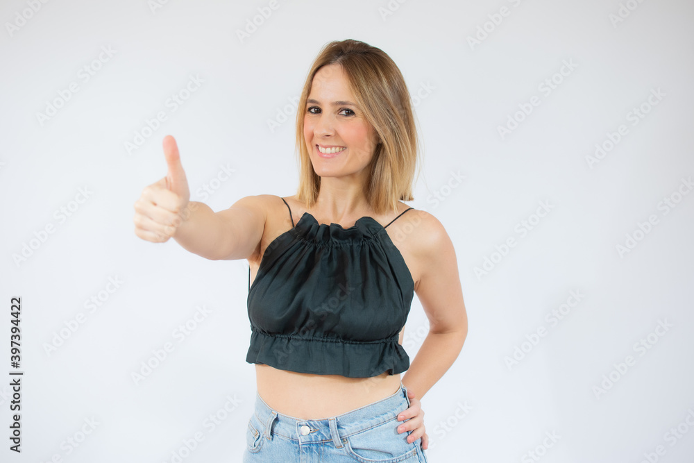 Young happy cheerful woman showing thumb up over white background. Young happy cheerful woman showing thumb up over white background.