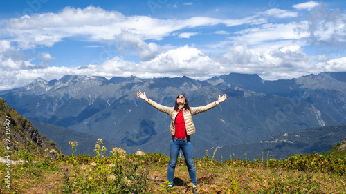 Embrace the world around, young woman in the mountains,