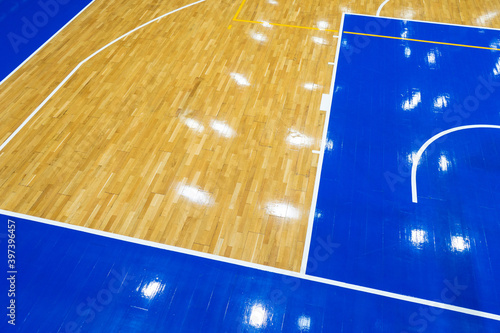 Top view of a part of an empty basketball court. the floor of the sports space is made of wood and painted blue