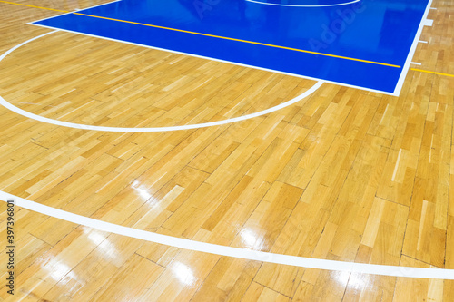 Top view of a part of an empty basketball court. the floor of the sports space is made of wood and painted blue