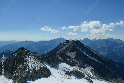 Panoramic view from top of Hohe Sonnblick in Austrian Alps on Gro glockner. The whole area is very steep and dangerous  with many lose stones. Many mountain chains in the back. Sunny day. Expedition