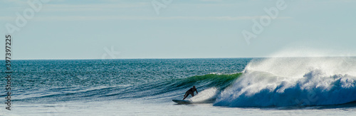 Vendée, France; November 29, 2020: from the Sauzaie spot, a black silhouette of a surfer on the point break, Bretignolles Sur Mer.

